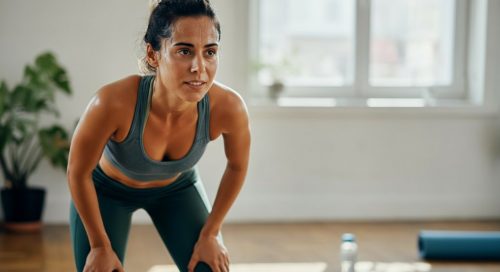 Frau atmet nach einer HIIT-Übung durch, motiviert in ihrem ersten Monat HIIT.