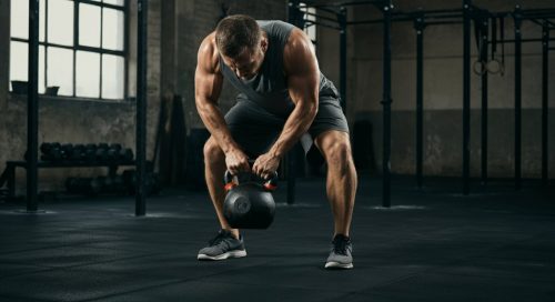 Athlet beim funktionellen Bodybuilding: Führt eine kraftvolle Übung mit einer Kettlebell aus.
