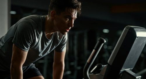 Athletische Person nach einem intensiven HIIT auf dem Stairmaster, die erschöpft, aber zufrieden ist.