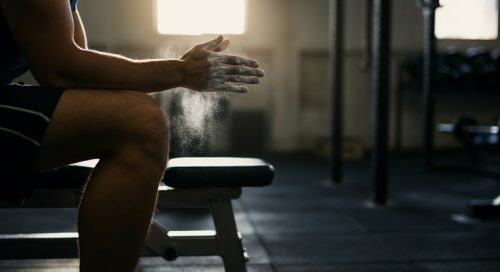 Konzentrierter Athlet plant sein Hypertrophietraining im Fitnessstudio.