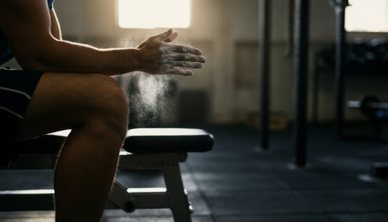 Konzentrierter Athlet plant sein Hypertrophietraining im Fitnessstudio.