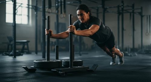 Ein Athlet pusht einen Schlitten als Teil seines Kraftausdauer Trainingsplans.