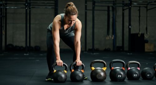 Ein Athlet wählt überlegt eine Kettlebell aus als Beispiel für ein smartes, scaled Crosstraining.