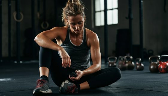 Athletin prüft nach dem Training die WOD Dauer auf ihrer Stoppuhr, um die Effektivität zu bewerten.
